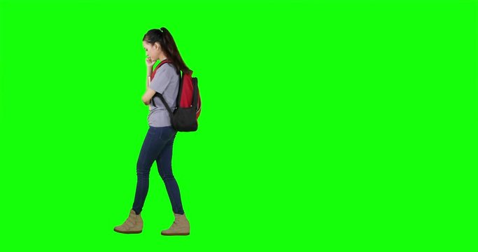 Full length of female high school student walking back and forth in the studio while thinking. Shot in 4k resolution with green screen background