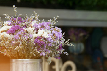 Closeup of Decorative Corrugated Zinc Vase with Violet Flowers