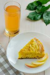 Slice of apple - curd cake with a glass of apple juice