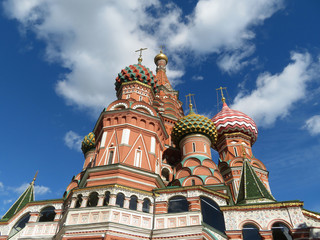 Fototapeta na wymiar St. Basil's Cathedral against the blue sky with white clouds. Russian architecture landmark, located on Red square in Moscow