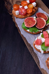 Assortment of bruschettas with figs, watermelon, cherry tomatoes, cheese and honey