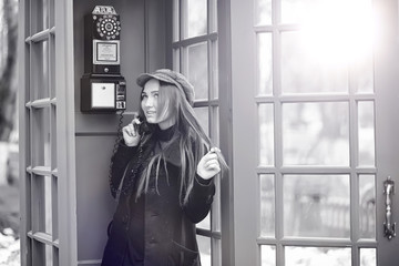 Beautiful young girl in a phone booth. The girl is talking on th