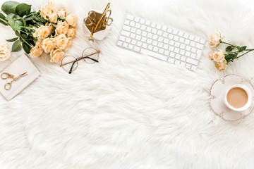 Female workspace with computer, roses flowers bouquet, golden accessories, diary, glasses on white background. Flat lay women's office desk. Top view feminine background.