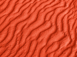 Fototapeta na wymiar texture of red sand waves on the beach or in the desert. the ripples of the sand is diagonal.