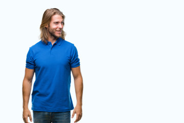 Fototapeta premium Young handsome man with long hair over isolated background looking away to side with smile on face, natural expression. Laughing confident.