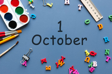 October 1st. Day 1 of month, calendar on blue school desk background. Autumn time. Empty space for text