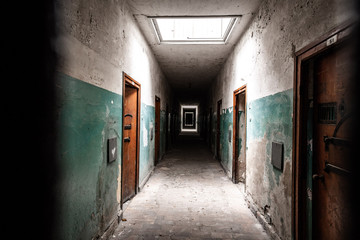 An old corridor of a creepy prison abandoned a long time ago. - obrazy, fototapety, plakaty