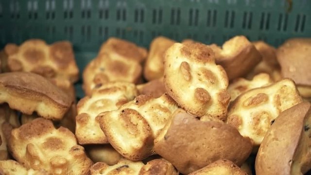 Tracking shot of delicious freshly baked teddy bears falling down into container at factory, close up