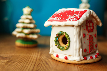Gingerbread house. Christmas holiday sweets. European Christmas holiday traditions. Christmas gingerbread house and holiday decorations on old wooden table