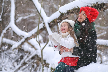 A winter fairy tale, a young mother and her daughter ride a sled