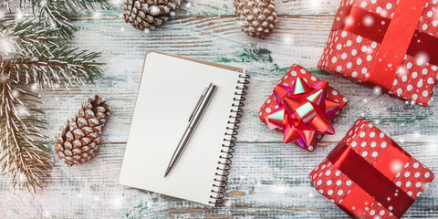 White, horizontal wooden background. Tree and fir cones, red gifts. Space for wishes with winter,...