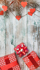 Wallpaper of white wood, vertical. Fir tree with hearts and red gifts. Space for wishes with...