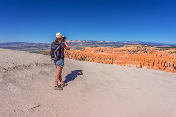 Obraz na płótnie Canvas girl takes picture in colorful Bryce Canyon National Park in Utah, USA