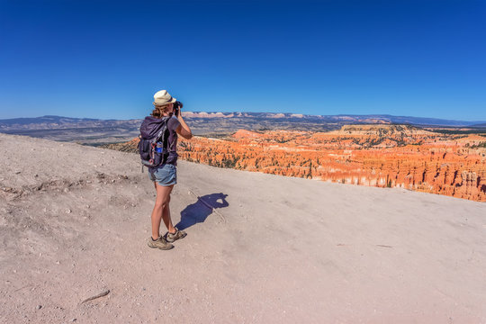 girl takes picture in colorful Bryce Canyon National Park in Utah, USA