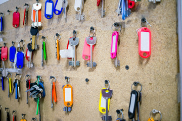  Many keys with multi-colored tags.  A board with lots of room keys hangs in the hostel. Selective...