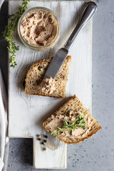 Fresh homemade liver pate in a glass jar and multigrain bread, selective focus.