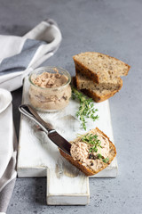 Fresh homemade liver pate in a glass jar and multigrain bread, selective focus.