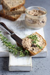 Fresh homemade liver pate in a glass jar and multigrain bread, selective focus.