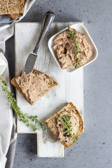 Fresh homemade liver pate in a glass jar and multigrain bread, selective focus.
