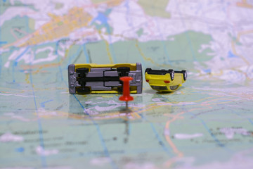Two upturned toy cars are on a paper map. Place of accident. Concept of accident vehicles....