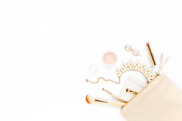 Beige cosmetic bag, makeup brushes, cosmetics, golden accessories on white background. Flat composition. magazines, social media. Top view. Flat lay. 