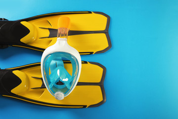 Pair of yellow flippers and diving mask on color background, top view with space for text © New Africa