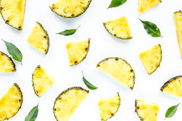 Naklejka premium Slices pineapple with green leaves isolated on white background. Flat lay, top view