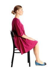 Woman sitting on chair against white background. Posture concept