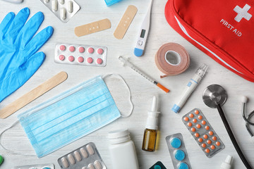 Flat lay composition with first aid kit on wooden background