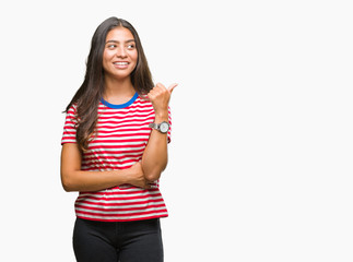 Young beautiful arab woman over isolated background smiling with happy face looking and pointing to the side with thumb up.