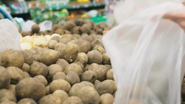 A woman in a supermarket buying vegetables