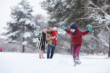 Young family with children are walking in the winter park. Winte