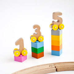 wooden numbers 0, 1, 2, 3, 4, 5 letters train cars alphabet with yellow wheels on white background. Early childhood education, learning to count, preschool and kids game concept