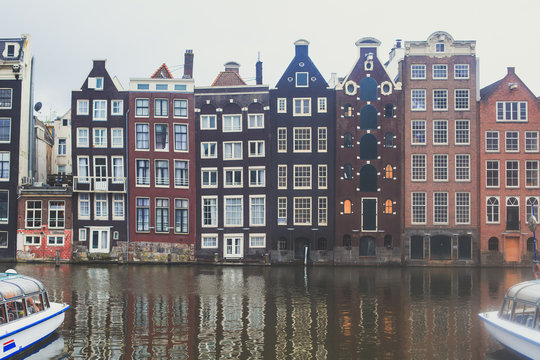 Summer view of the "Dancing Canal Houses of Damrak' , iconic canal houses in the capital city of Amsterdam, Netherlands