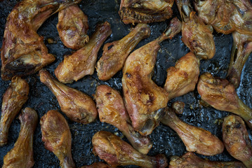 Grilled chicken drumsticks background, top view, close-up. Roasted chicken legs, Cooked with sauce