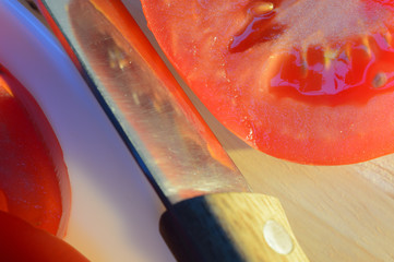 tomatoes on a white plate on wooden table lit by the sun