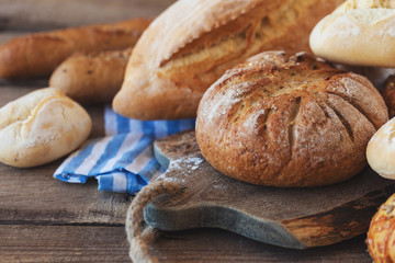 Fresh fragrant bread, rustic crusty loaves of bread and buns on the table