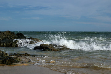 Fototapeta na wymiar waves facing stones on the beach