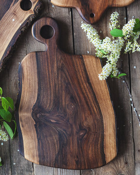 Handmade Walnut cutting Board on rustic wooden table with bark on 2 sides 