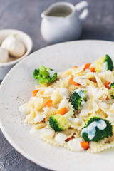Homemade farfalle with with broccoli and carrots, bechamel