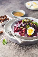 salad from boiled beet, young leaves of spinach and beets with honey-garlic sauce and egg