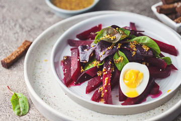 salad from boiled beet, young leaves of spinach and beets with honey-garlic sauce and egg