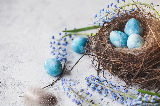 happy easter! decorated quail eggs in a nest on a light background