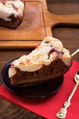 Cut a piece of cake with cottage cheese on a glass round plate.
