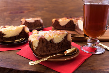 Dessert of chocolate cake with cottage cheese and tea, wooden background, cake spoons.