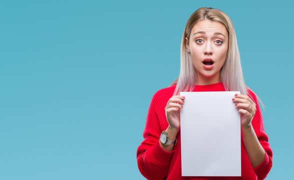 Young blonde woman holding blank paper sheet over isolated background scared in shock with a surprise face, afraid and excited with fear expression