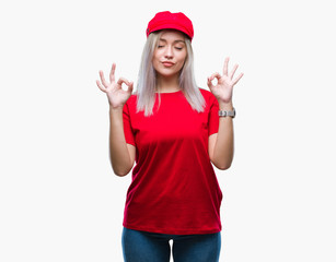 Obraz na płótnie Canvas Young blonde woman wearing red hat over isolated background relax and smiling with eyes closed doing meditation gesture with fingers. Yoga concept.