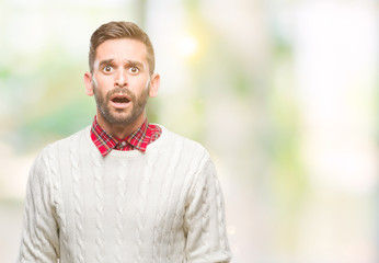 Young handsome man wearing winter sweater over isolated background afraid and shocked with surprise expression, fear and excited face.