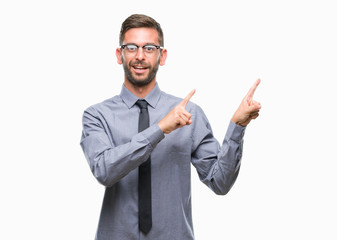 Young handsome business man over isolated background smiling and looking at the camera pointing with two hands and fingers to the side.