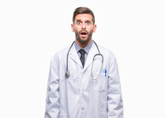 Fototapeta premium Young handsome doctor man over isolated background afraid and shocked with surprise expression, fear and excited face.